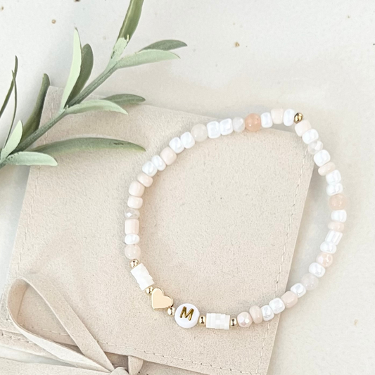 DIY Set für Perlenarmband mit 4mm kleinen hellen Perlen in weiß, creme, zart peach. In der Mitte befinden sich weiße Katsuki Perlen, ein 18k vergoldetes Herz und eine Buchstabenperle mit Initialen.